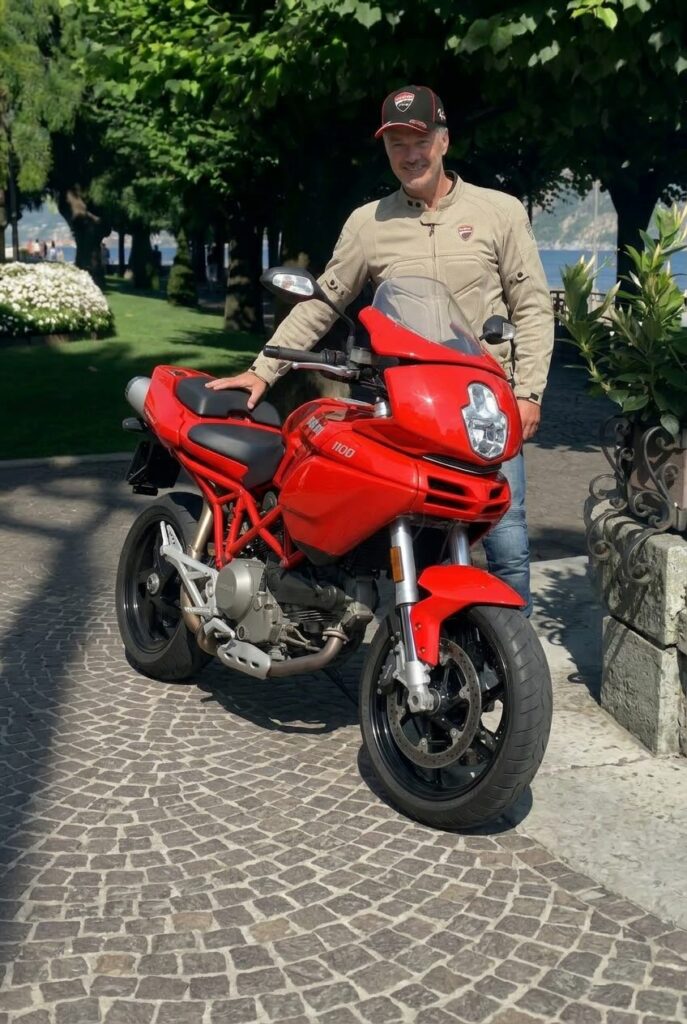 Guus Groen poserend voor zijn rode Ducati Multistrada 1100 motorfiets